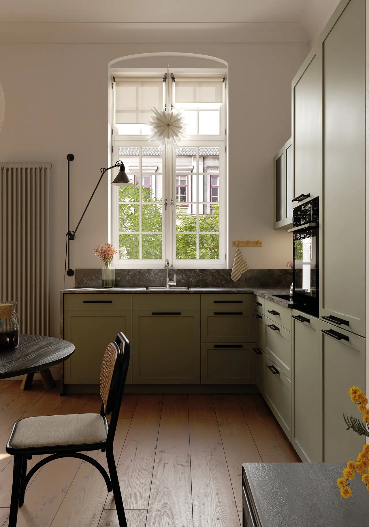 Helle Landhausküche mit großem Fenster, salbeifarbenen Fronten, Naturstein Arbeitsplatte, schwarzer Armatur und gemütlichem Holzboden, stilvolles Küchendesign mit modernem Stauraum und natürlicher Beleuchtung.